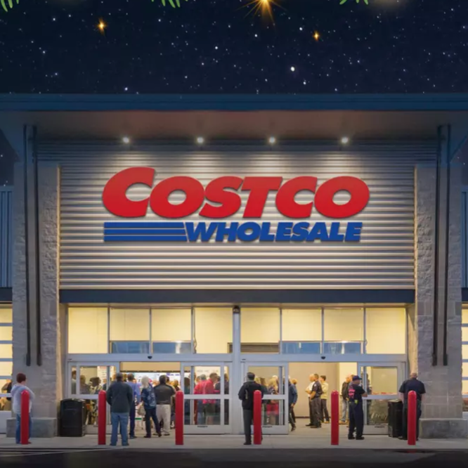 A Costco store entrance is decorated with holiday lights and pine branches, with people visible inside and outside.