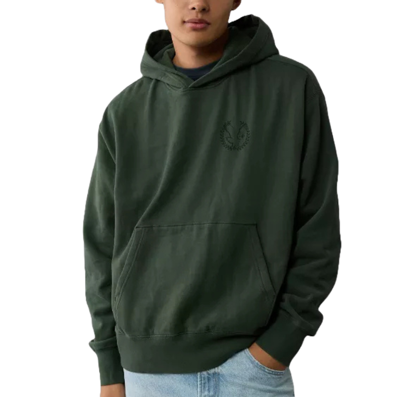 A dark green hoodie with a kangaroo pocket and a small laurel wreath logo on the chest. The hoodie is paired with light blue jeans.