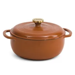 A round, brown enameled cast iron Dutch oven with a lid and side handles, featuring a gold knob on top.