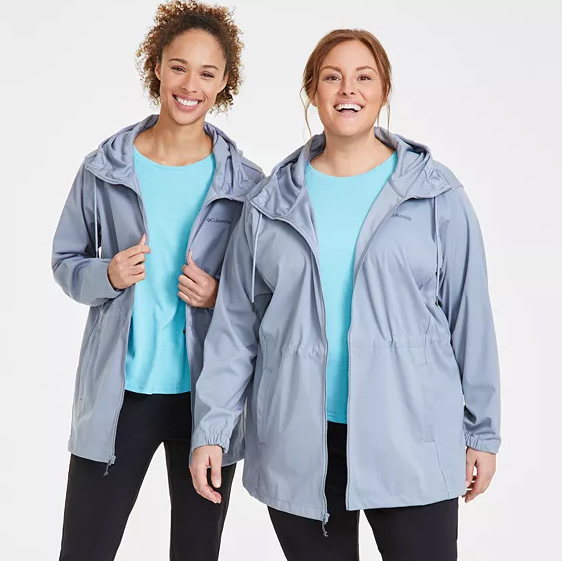 Two women are wearing Columbia Rose Winds Jackets in light blue, featuring adjustable hoods and zippered front pockets.
