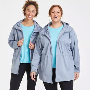 Two women are wearing Columbia Rose Winds Jackets in light blue, featuring adjustable hoods and zippered front pockets.