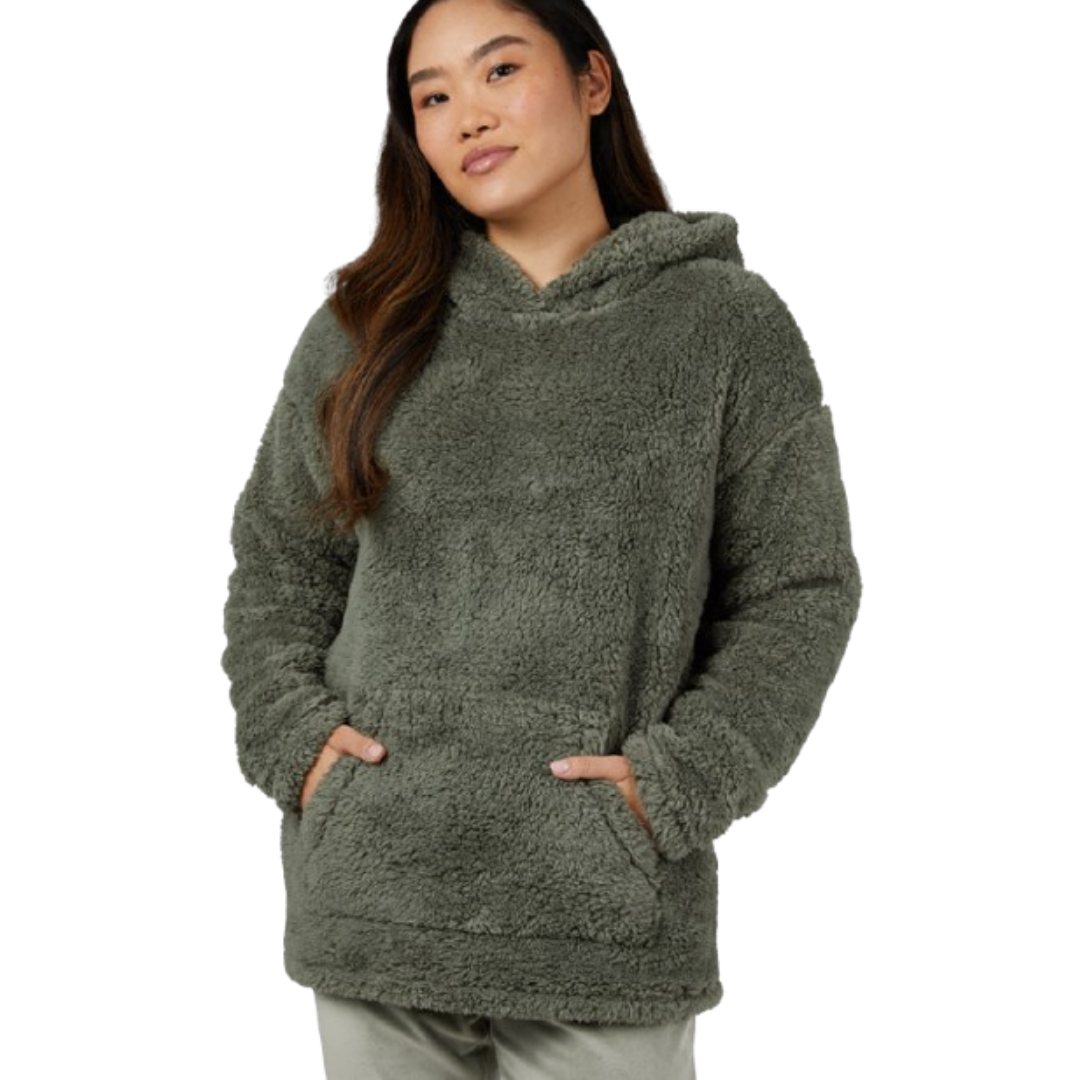 A person is wearing a cozy, oversized, olive-green sherpa hoodie with a large front pocket and hood.