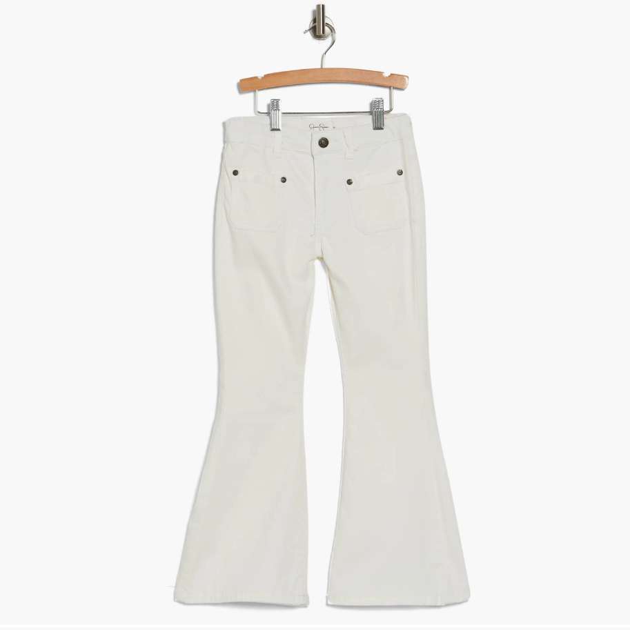 A pair of white flared jeans displayed on a wooden hanger.