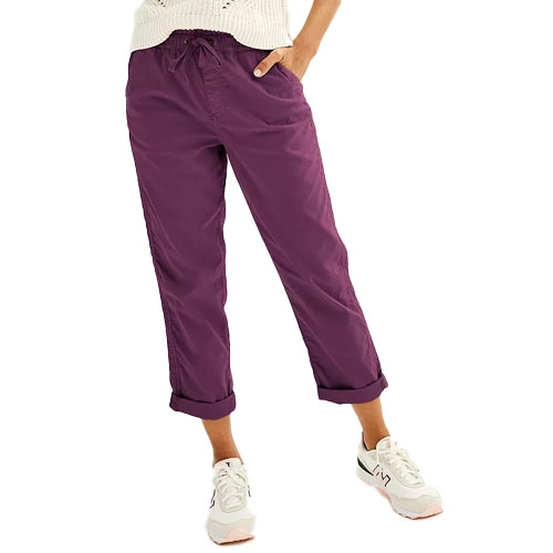 Purple cropped pants with a drawstring waist, paired with white sneakers and a knitted sweater.