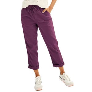 Purple cropped pants with a drawstring waist, paired with white sneakers and a knitted sweater.