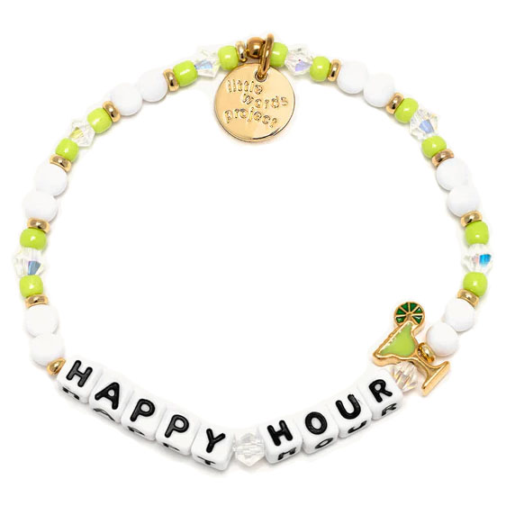 The Little Words Project Happy Hour Bracelet features white and light green beads with a gold charm displaying the phrase \“HAPPY HOUR.\“ It includes a small cocktail charm and gold accents, adding a playful touch to the design.