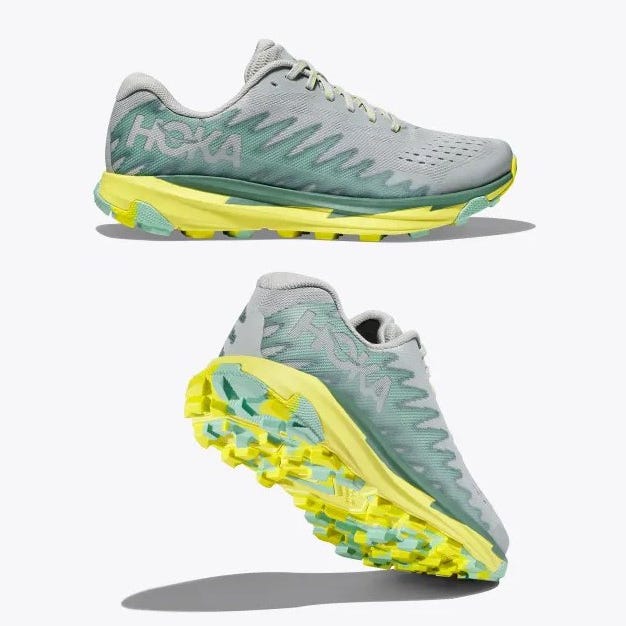 A pair of Hoka running shoes with a grey upper and yellow outsole.