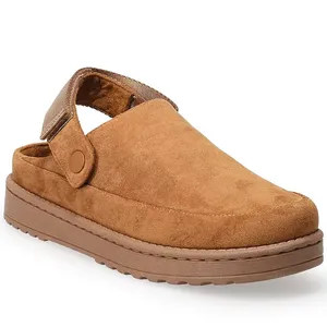 A tan suede clog with a thick sole and adjustable strap, featuring a button detail for closure.
