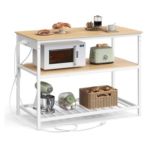 Kitchen storage rack with three shelves featuring a microwave, toaster, stand mixer, a jar of garlic, a basket of potatoes, and a top shelf with a plate of croissants and coffee-making items.