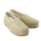 White espadrille platform shoes with a yellow and gray floral pattern and woven rope soles.