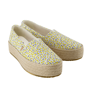 White espadrille platform shoes with a yellow and gray floral pattern and woven rope soles.