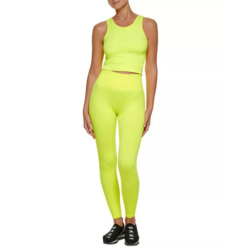 Bright neon yellow high-waisted leggings paired with a matching crop tank top, featuring a seamless design for a snug fit, complemented by black sneakers labeled \“DKNY.\“