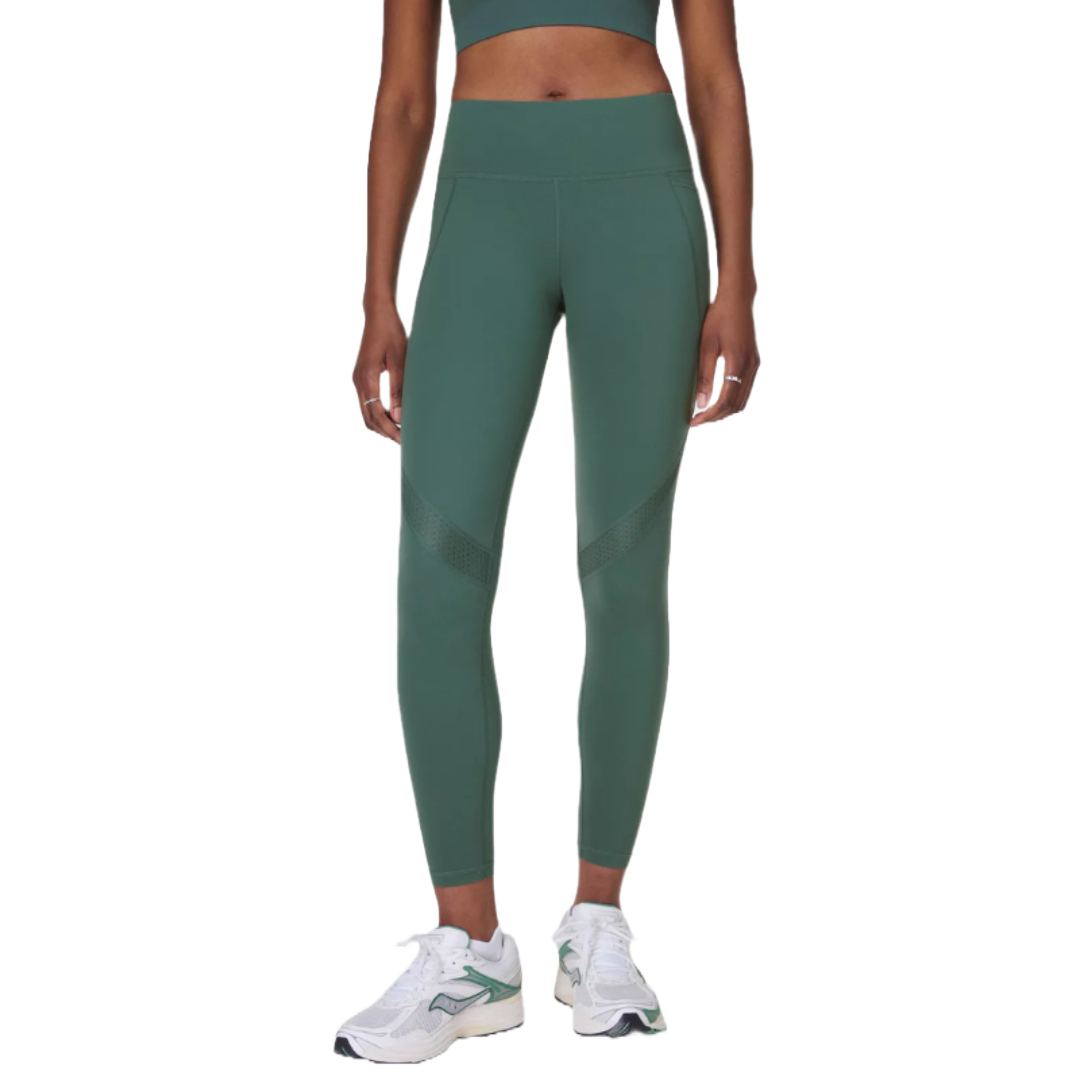 High-waisted green workout leggings with mesh accents above the knees, paired with white athletic shoes.