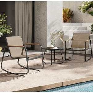 3-piece patio set includes two beige mesh rocking chairs with black metal frames and wooden armrests, paired with a small black round side table. Decorated with plants, the setup is situated next to a pool on a stone patio.