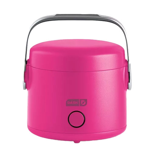A pink electric lunch box with a handle, branded \“Dash,\“ featuring a simple circular button on the front.