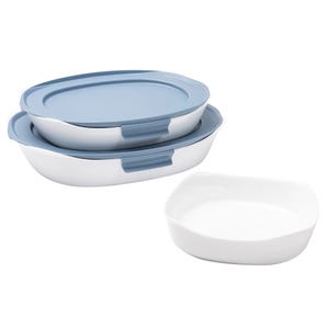Stacked white containers with blue lids, suitable for food storage or baking, alongside an additional empty white dish.