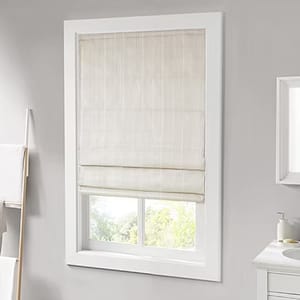 Light-colored Roman shade covering a rectangular window, surrounded by a white frame in a gray-walled room. A partial view of a towel rack and bathroom sink is visible nearby.