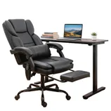An ergonomic black office chair with footrest and an adjustable desk holding a laptop, plant, and books.