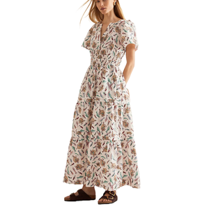 A V-neck tiered maxi dress with a short-sleeved design and an elastic waist, featuring a pattern of colorful butterflies on a light background, paired with brown sandals.