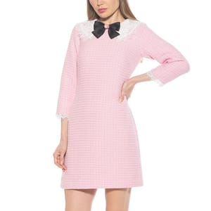 A pink long-sleeve shift dress with a textured pattern, featuring a white lace collar with a black bow and lace trim on the sleeves.
