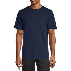 A man wearing a plain navy blue short-sleeve t-shirt and dark pants.