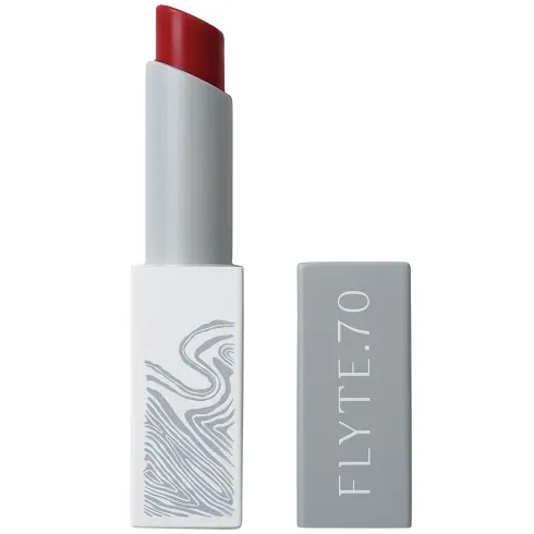 A lipstick with a red shade, housed in a sleek gray case with the brand name \“FLYTE.70\“ on the lid.