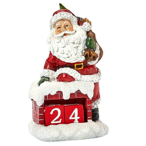 A Santa Claus figurine wearing a red suit sits atop a snowy chimney with interchangeable blocks displaying the number \“24,\“ serving as a Christmas countdown calendar.