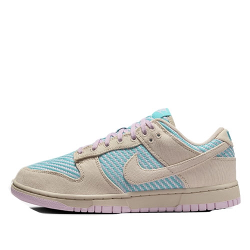 Nike Women's Dunk Low Shoes in a light beige with teal woven pattern, featuring lilac accents on the laces and outsole. The design includes a classic low-top silhouette with a signature swoosh logo on the sides.
