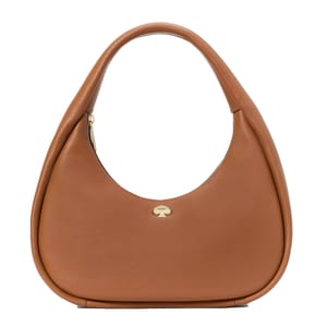 A Kate Spade Crescent Shoulder Bag in tan leather with a curved silhouette, featuring a simple gold Spade logo accent on the front. The bag has a top handle and a zip closure.
