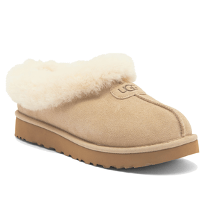 Tan slip-on clog with fluffy shearling lining and a rubber sole, featuring the UGG logo.