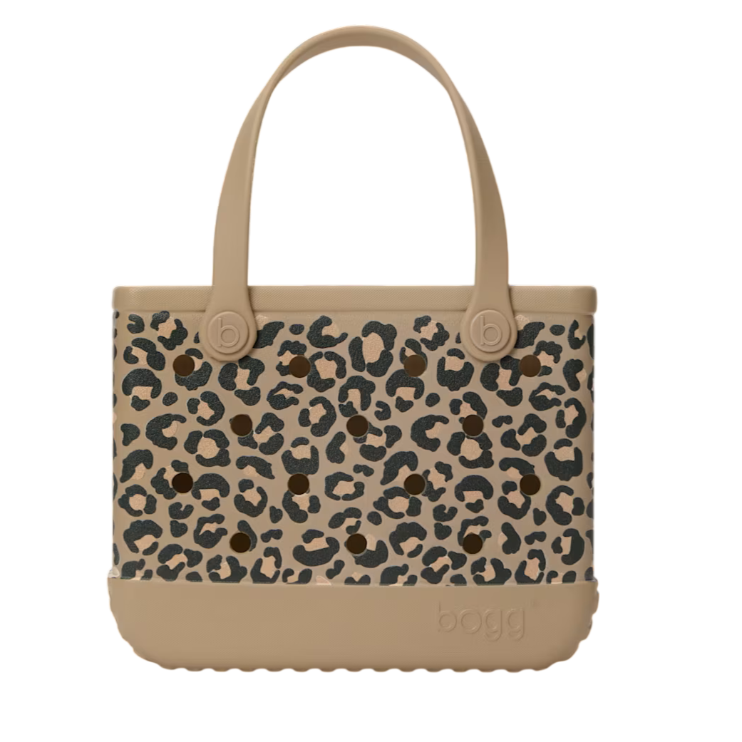 A leopard print tote bag with beige trim and handles, featuring a textured bottom layer and the brand name \“bogg\“ embossed on the surface.