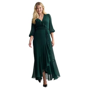 Woman wearing a dark green, long-sleeved, wrap-style dress with a V-neckline and ruffled hem, paired with black heels.