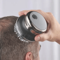 A handheld electric head shaver is being used on a man's head, designed for convenient and quick hair trimming.