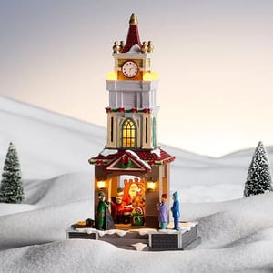 An LED-lit tower with festive decorations and a clock, featuring a scene of Santa Claus interacting with people and pets, set against a snowy background adorned with small snowy trees.