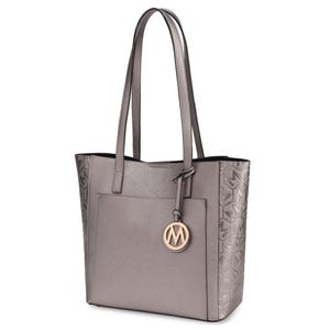 Gray tote bag with long straps, featuring a textured side pattern and a round logo charm hanging from one handle.