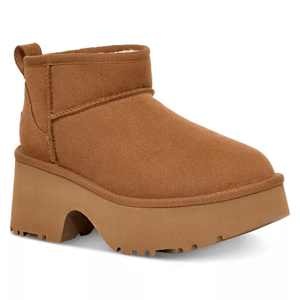 The UGG Mini New Heights Boots are tan ankle-height boots featuring a chunky, platform sole with textured tread for added grip. They have a simple, slip-on design with visible stitching and a pull tab at the back.