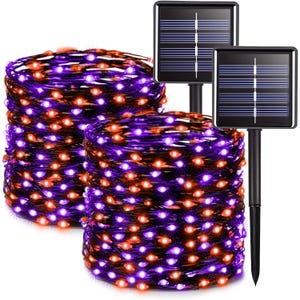 Two coils of solar-powered string lights with orange and purple LEDs, each equipped with a solar panel on a stake.