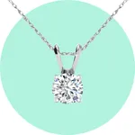 A silver necklace with a round diamond solitaire pendant on a delicate chain against a mint green background.