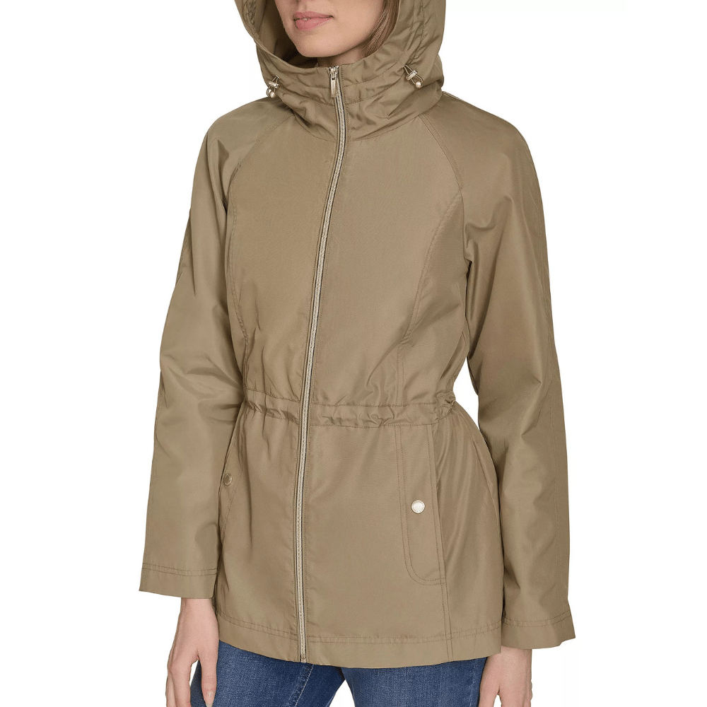 Beige hooded jacket with a front zipper, drawstring waist, and two front pockets, worn over blue jeans.