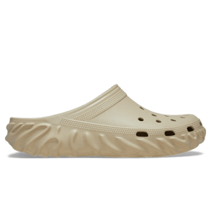 A beige slip-on clog with a textured sole and ventilation holes on the top.
