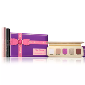 Too Faced Makeup Set includes a purple and pink-themed eyeshadow palette with six shades, a Better Than Sex mascara, and an eye shadow primer. The packaging is vibrant with a bow design.