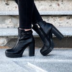 A pair of black platform ankle boots with high block heels and side zippers.