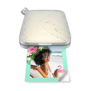 An HP Sprocket Printer is shown, a compact photo printer with a marble-design top, alongside a two-pack of printing paper with a beach-themed photograph printed on one sheet.