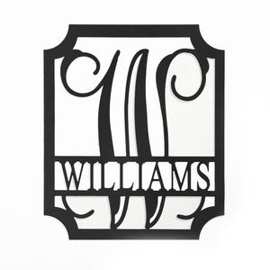 A black 12\“ monogram wall sign featuring the letter \“W\“ in an elegant, stylized design, with the name \“Williams\“ in bold letters below.
