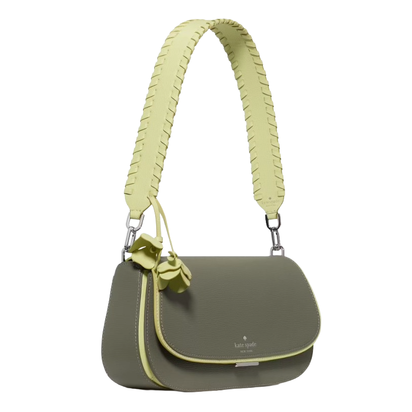 A small green crossbody bag with a wide, braided shoulder strap and floral charms, featuring the \“kate spade new york\“ logo.