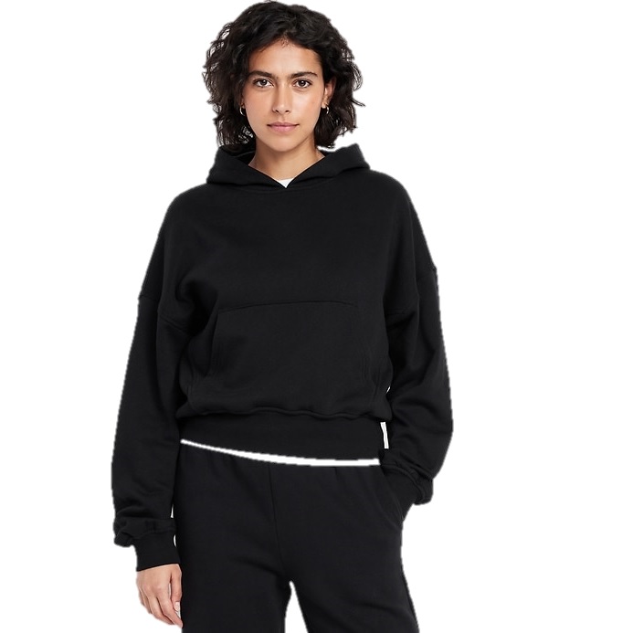 A person wearing a black hoodie with a front pocket and black pants, posing against a white background.