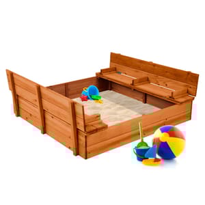 47\“ cedar sandbox with built-in benches, filled with sand, includes toy accessories like a colorful beach ball, bucket, shovel, and star mold. The benches fold down for covering the sandbox when not in use.