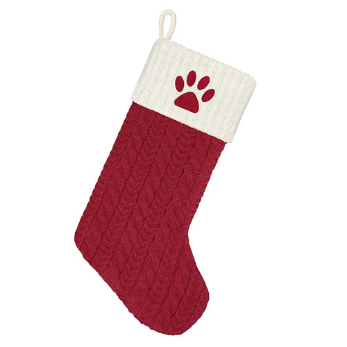 A red and white knitted Christmas stocking with a paw print design on the cuff.