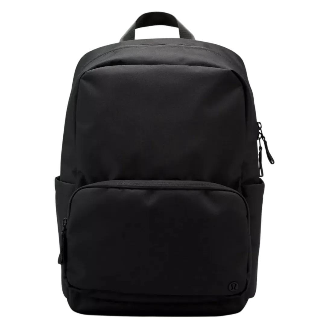 A sleek black backpack with a minimalist design, featuring a large main compartment, a front zippered pocket, and a top handle for easy carrying.