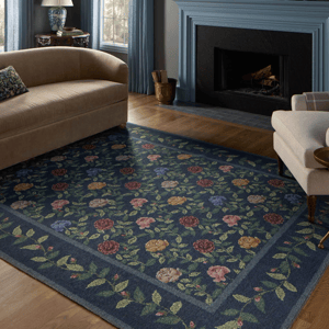 8' x 10' floral area rug with a blue background and colorful flowers, placed in a living room with neutral-toned furniture and a blue fireplace.